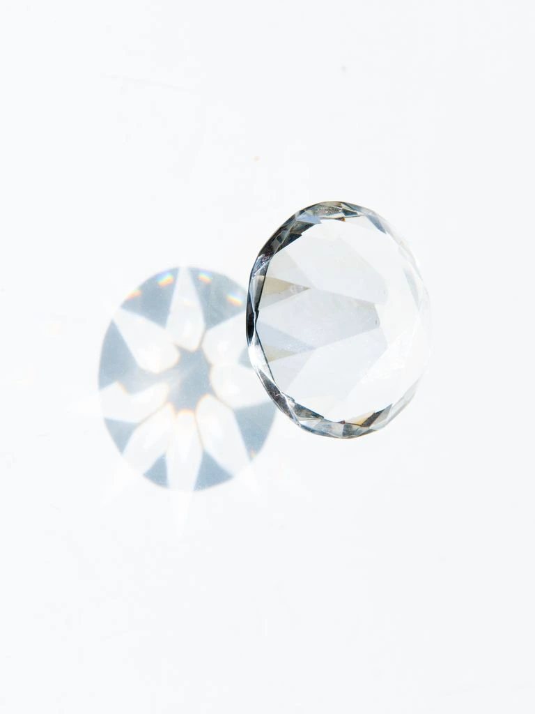 A round brilliant-cut aquamarine, top-down view on cream parchment