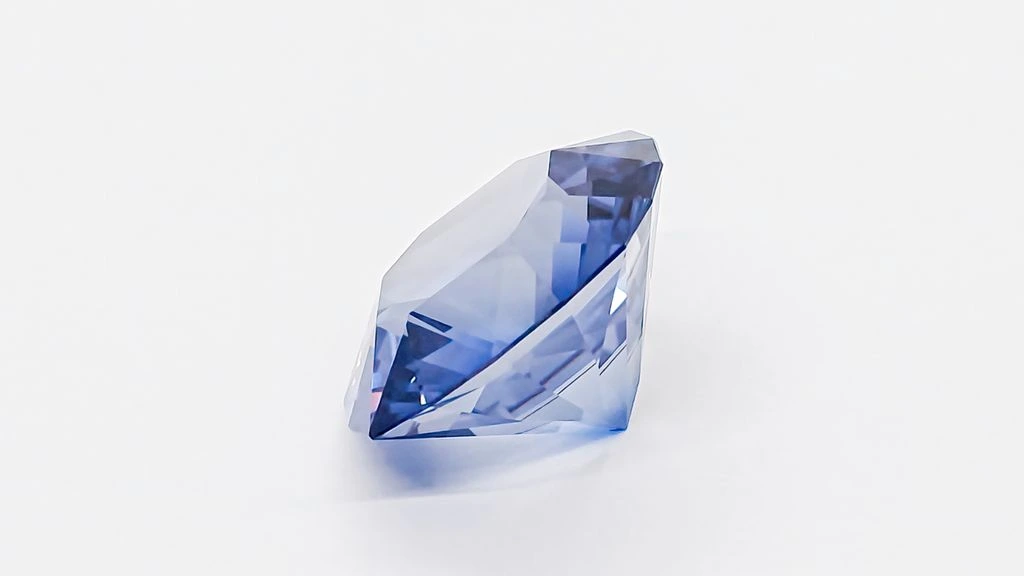 A single faceted aquamarine on midnight velvet, lit to reveal its cold blue body