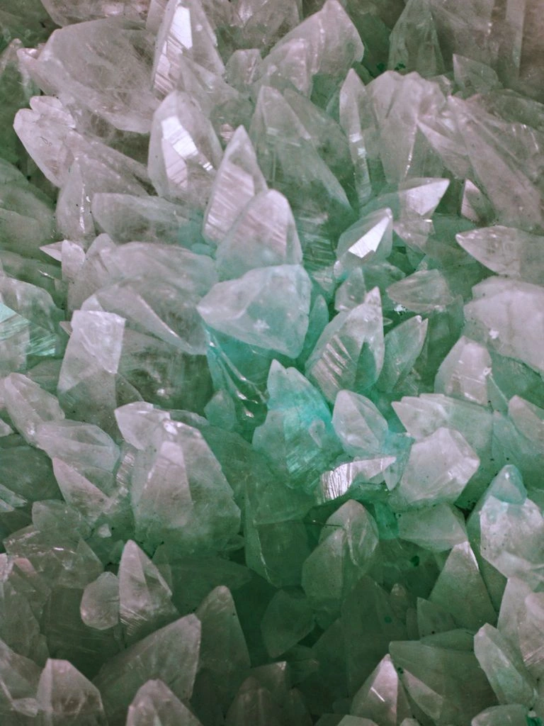 A finished aquamarine beside a grading loupe and a draft certificate